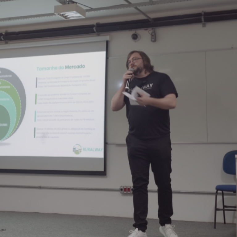 Apresentação da RuralWay sobre logística rural, rotas seguras, IA e navegação offline, realizada em evento acadêmico na UTFPR com slide mostrando análise de mercado.